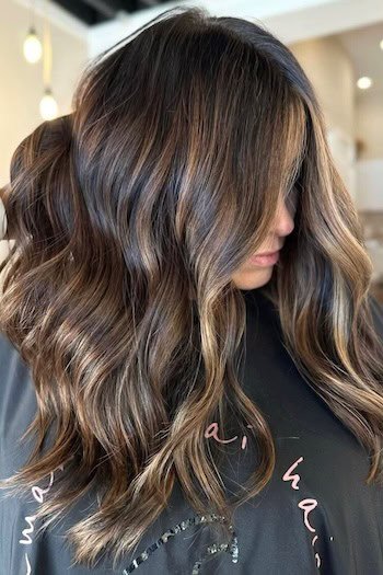 Brown Hair With Soft Golden-Brown Balayage hair color on a woman with long brown hair.