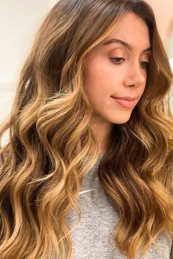 Warm Brown With Caramel Blonde Highlights hair color on a woman with brown hair.