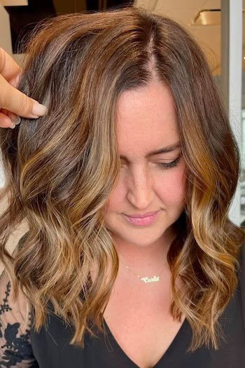 Brunette With Soft Golden Highlights hair color on a woman with brown hair.