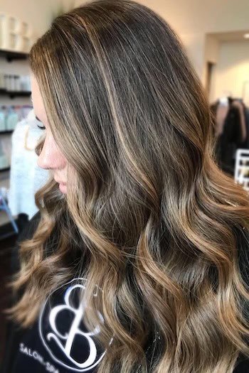 Ash Brown Hair With Subtle Blonde Highlights hair color on a woman with brown hair.