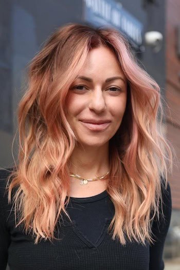 Rose Gold Waves On Brown Hair on a woman with below shoulder-length hair.