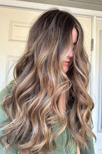 Rich Mocha Brown With Golden Blonde Ribbons hair color on a woman with long brown hair.