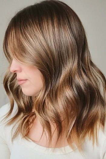 Soft Caramel-Brown Balayage hair color on a woman with brown hair, side view.