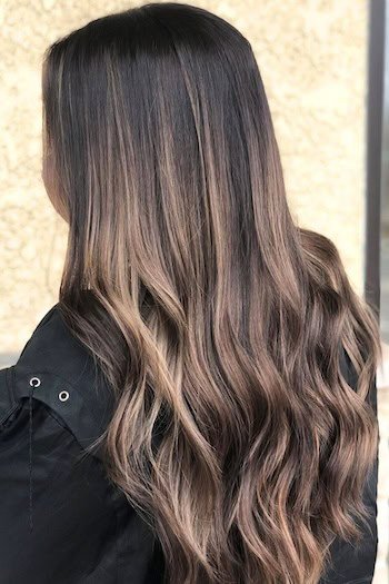 Cool Brunette With Blonde and Light Brown Babylights hair color on a woman with long hair.